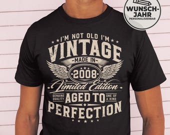 May include: Black t-shirt with a vintage design. The shirt features the text "I'M NOT OLD I'M VINTAGE MADE IN 2008 Limited Edition AGED TO PERFECTION." A circular graphic with the text "WUNSCH-JAHR PERSONALISIERBAR" is on the right.