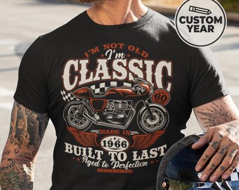 May include: Black t-shirt with a motorcycle graphic and the text "I'M NOT OLD I'm CLASSIC". The graphic includes the text "MADE IN 1966" and "BUILT TO LAST Aged to Perfection". A custom year option is available.