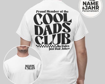 May include: White t-shirt with the text "Proud Member of the COOL DADS CLUB" in large, bold, black letters. The shirt also features the phrase "No Rules just Dad Jokes". A small circular graphic on the shirt says "MARIE LUKAS".