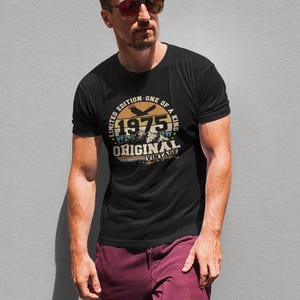 Puede incluir: Camiseta negra con un dise&ntilde;o gr&aacute;fico circular que presenta el a&ntilde;o "1975", monta&ntilde;as y un &aacute;guila. El dise&ntilde;o incluye las palabras "Edici&oacute;n Limitada - &Uacute;nica" y "Original Vintage".
