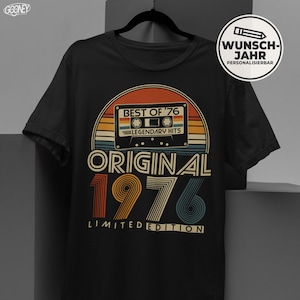 Könnte beinhalten: Schwarzes T-Shirt mit Retro-Design, das eine Kassette und den Text "BEST OF '76 LEGENDARY HITS" zeigt. Das Shirt zeigt auch "ORIGINAL 1976 LIMITED EDITION" in einer Vintage-Schrift. Ein rundes Logo mit dem Text "WUNSCH-JAHR PERSONALISIERBAR" befindet sich auf der rechten Seite.