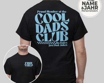 May include: Black t-shirt with the text "Proud Member of the COOL DADS CLUB" in light blue. The shirt also features the text "No Rules just Dad Jokes". A smaller image shows a black t-shirt with the names "FINN THEO" in light blue.