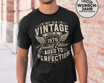 May include: Black t-shirt with a vintage design. The shirt features the text "I'M NOT OLD I'M VINTAGE - MADE IN - 1976 - Limited Edition - AGED TO PERFECTION". The design includes wings and stars.