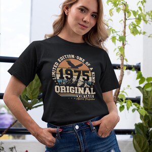 Puede incluir: Camiseta negra con un dise&ntilde;o vintage con el a&ntilde;o "1975", la palabra "ORIGINAL" y la frase "Limited Edition - One of a Kind". El dise&ntilde;o incluye un &aacute;guila y un gr&aacute;fico de monta&ntilde;a.