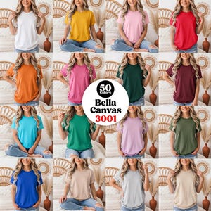 Könnte beinhalten: Eine Kollektion von sechzehn Bella Canvas 3001 T-Shirts in verschiedenen Unifarben, darunter Weiß, Gelb, Pink, Rot, Orange, Magenta, Dunkelgrün, Kastanienbraun, Türkis, Grün, Lavendel, Oliv, Blau, Hellbraun, Grau und Beige, in einem Raster.