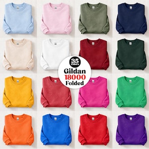 Peut inclure: Une collection de seize sweat-shirts à col rond Gildan 18000 pliés dans diverses couleurs unies, notamment bleu clair, rose, olive, marine, beige, blanc, bordeaux, vert foncé, jaune, rouge, magenta, vert vif, orange, bleu roi et violet.
