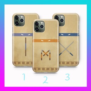 Op de afbeelding: Drie beige smartphonehoesjes met gestileerde karakterontwerpen met gekleurde oogmaskers, wapengraphics en de tekst HERO of HEROS onderaan. Elk hoesje toont een uniek wapen: een bo-staf, nunchucks of twee gekruiste katana's.
