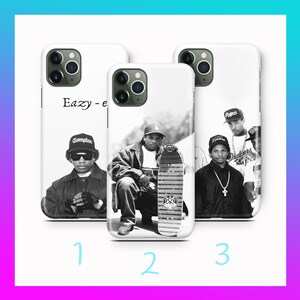 Puede incluir: Tres fundas blancas para teléfono con imágenes en blanco y negro de un rapero. La primera funda tiene el texto "Eazy - e" y una foto del rapero con un sombrero de Compton. La segunda funda tiene una foto del rapero con una patineta. La tercera funda tiene una foto del rapero con otras personas.