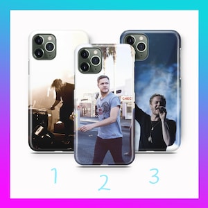 Op de afbeelding: Drie telefoonhoesjes met afbeeldingen van een muzikant. De hoesjes zijn wit en zwart, met afbeeldingen van de muzikant op het podium en buiten. Ontworpen voor een smartphone.