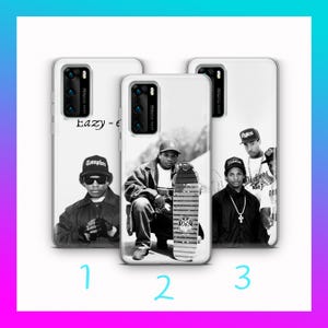 Może przedstawiać: Trzy białe etui na telefon z czarno-białymi zdjęciami raperów. Pierwsze etui przedstawia Eazy-E, drugie Eazy-E ze deskorolką, a trzecie grupę raperów. Etui mają czarny moduł aparatu.