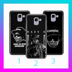 May include: Three black phone cases with graphic designs. One case features a portrait with sunglasses and the text "Real G's Stay Ruthless". Another case displays a portrait with the text "Eazy E". The third case shows a skull with the text "Compton".