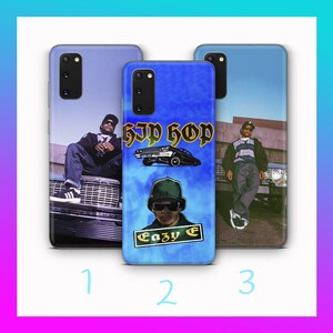 May include: Three phone cases with images of a person and the text "Eazy E" and "Hip Hop". The cases are blue and have images of a person wearing a hat and sunglasses. The cases are for a Samsung phone.