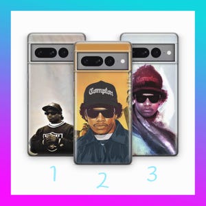 May include: Three phone cases with images of a man wearing sunglasses and a hat. The cases have different backgrounds, including a marble pattern and a sunset scene. The word "Compton" is visible on one of the hats.