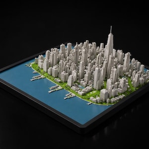 May include: A detailed miniature cityscape model, featuring numerous gray skyscrapers and buildings, with a prominent central tower. The model includes a blue water feature and green park areas, all set within a black frame.