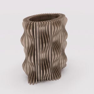 May include: A light brown, wooden vase with a unique, wavy design. The vase has an oval opening at the top and is constructed from vertical, curved wooden slats. The overall shape is cylindrical with a textured, organic appearance.