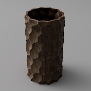 May include: A tall, dark brown wooden vase with a textured, honeycomb-like pattern. The vase has a wide opening and a geometric design, suitable for home decor.
