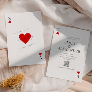 May include: Two white wedding invitation cards with Ace of Hearts symbols. One card reads "we are getting married" with a red heart. The other card invites guests to Emily & Alexander's wedding in Las Vegas.