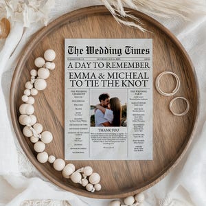 May include: A newspaper-style wedding announcement with a photo of the couple. The headline reads "A Day to Remember Emma & Micheal to Tie the Knot". The announcement lists the wedding ceremony and reception details, including the officiant, maid of honor, best man, bridesmaids, groomsmen, flower girl, ring bearer, and ushers.