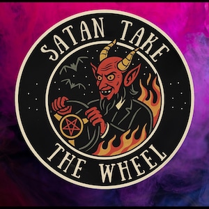 May include: Circular sticker with a cartoon illustration of a red devil driving a car, surrounded by flames. The text "SATAN TAKE THE WHEEL" is written around the edge of the sticker. The devil is holding a steering wheel with a pentagram.