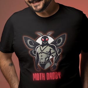 May include: Black t-shirt with a graphic of a muscular moth with red eyes and the text "MOTH DADDY" in red.