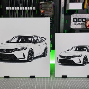 May include: Two white prints of a car, one large and one small, displayed side-by-side. The car is a modern hatchback with black wheels and a rear spoiler. The prints are on white backgrounds.