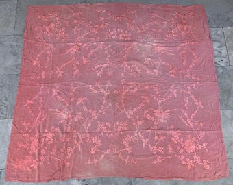 May include: A large, rectangular, pink textile with an intricate floral and bird pattern. The design features branches, flowers, and birds in a lighter shade of pink, creating a delicate and detailed aesthetic. The fabric appears to be thin and lightweight.