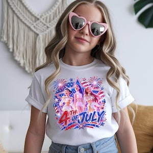 Puede incluir: Camiseta blanca con un gr&aacute;fico colorido que celebra el 4 de julio. El dise&ntilde;o presenta tres personajes de dibujos animados, fuegos artificiales y el texto "4th of July" en rojo y azul. La camiseta la lleva una persona con gafas de sol rosas en forma de coraz&oacute;n.