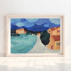 以下が含まれることがあります： 黄色い建物、道路、大きな緑の木がある村の風景を描いた、額入りの風景画。空は濃い青色で、白い雲の形をしています。アートワークは白い壁に展示されています。