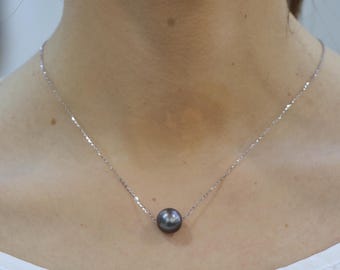 May include: A single dark gray pearl pendant suspended on a thin, delicate silver-toned chain. The round, lustrous pearl is centered on the necklace, which features a simple link design that rests against the base of the neck.