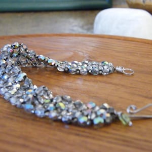 May include: A silver-toned multi-strand beaded bracelet with iridescent glass beads and silver-toned wire clasps.