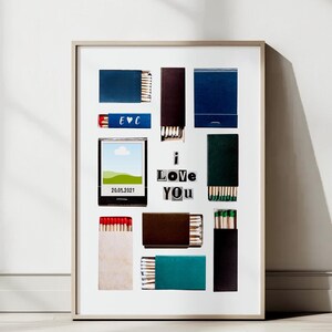 Pode incluir: Uma impressão emoldurada com fundo branco que apresenta uma colagem de caixas de fósforos. As caixas de fósforos estão dispostas em uma grade e apresentam vários designs, incluindo uma caixa azul com as letras "EVC", uma caixa com uma pequena imagem de paisagem e uma caixa com as palavras "I Love You" escritas em letras pretas.