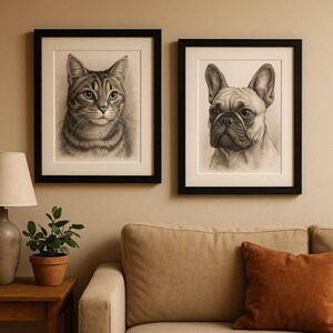 May include: Two framed pencil drawings of animals hang on a wall. One is a detailed portrait of a tabby cat, and the other is a French bulldog. Both are in black frames with white matting, creating a classic art display.
