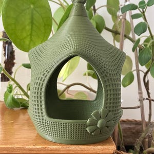 House-shaped bird feeder with flower decoration