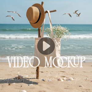 May include: A straw sun hat with a black band hangs on a wooden post next to a beige tote bag filled with white flowers. The bag has a video play button graphic. The words "VIDEO MOCKUP" are across the bottom of the image. Seagulls fly in the background.