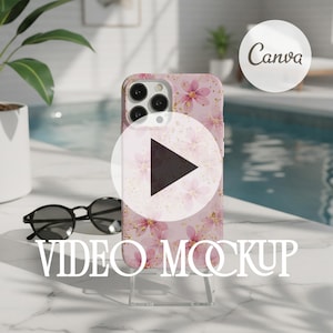 May include: A pink phone case with a floral design and gold accents, displayed on a clear stand. The case is next to black sunglasses. The words "VIDEO MOCKUP" are displayed in white text.
