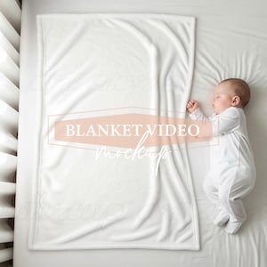 K&ouml;nnte beinhalten: Eine wei&szlig;e Babydecke mit weicher Textur liegt auf einem Bett neben einem schlafenden S&auml;ugling in einem wei&szlig;en Strampler. Die Decke hat eine rechteckige Form. Der Text "BLANKET VIDEO mockups" ist auf die Decke gelegt.