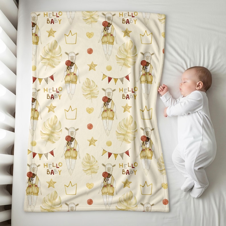 K&ouml;nnte beinhalten: Eine cremefarbene Babydecke mit einem sich wiederholenden Muster eines Lamms mit Latzhose, Kronen, Sternen und dem Text "HELLO BABY". Die Decke hat auch Bl&auml;tter, Herzen und Wimpel im Aquarellstil. Ein schlafendes Baby liegt neben der Decke.