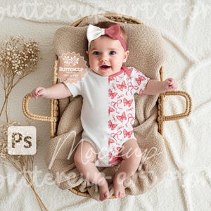 Peut inclure: Un bébé portant un body blanc et rose avec un motif papillon. Le body est blanc à l'avant et rose à l'arrière avec un motif papillon. Le bébé est allongé dans un panier en osier sur une couverture blanche.