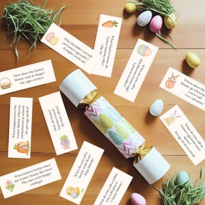May include: An Easter-themed party cracker with a pastel egg design, surrounded by joke cards, decorative eggs, and grass. The cards feature Easter-related puns and riddles. A festive and playful arrangement.
