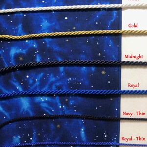 May include: Close-up of several twisted cords in various colors: white, gold, midnight, royal blue, navy, and royal thin. The cords are displayed against a dark blue fabric with a starry pattern, with each color labeled.