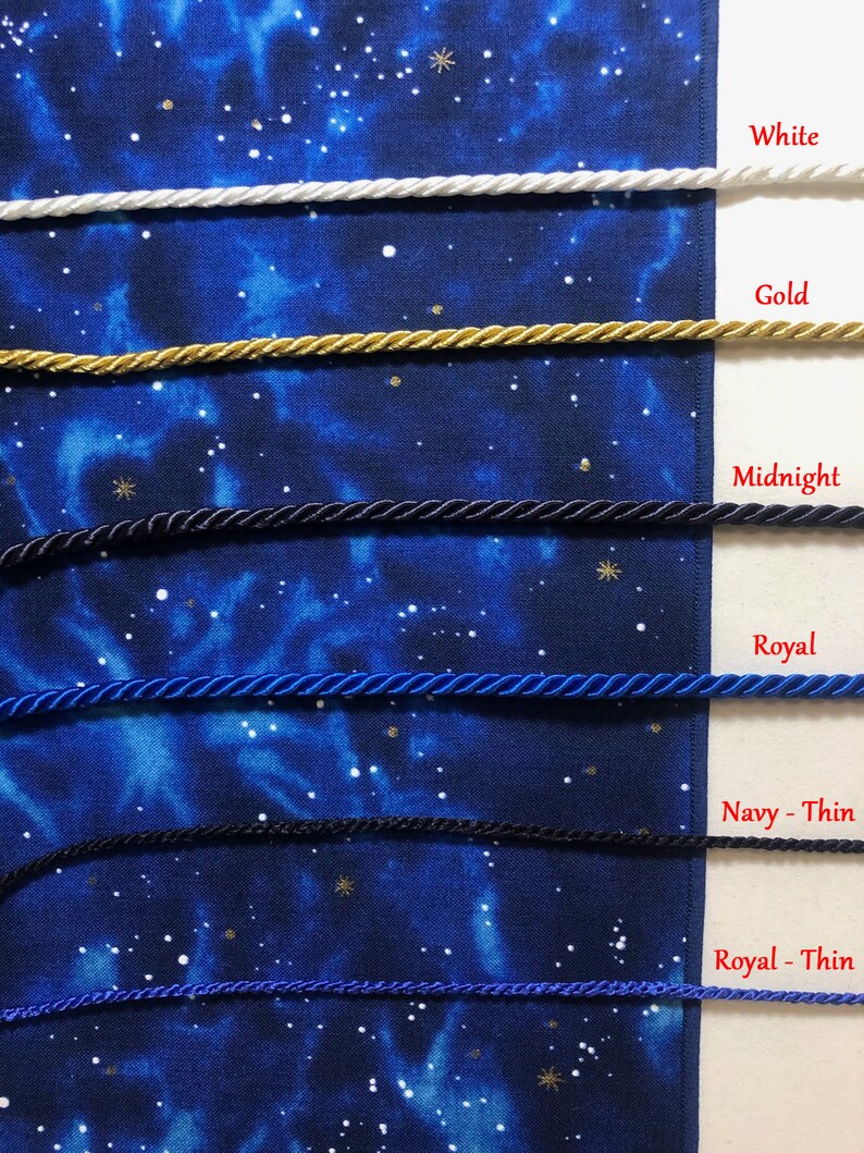 May include: Close-up of several twisted cords in various colors: white, gold, midnight, royal blue, navy, and royal thin. The cords are displayed against a dark blue fabric with a starry pattern, with each color labeled.