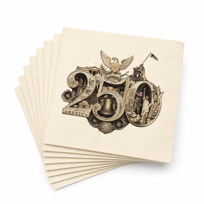 Puede incluir: Una pila de servilletas de papel blanquecino. Cada servilleta presenta una detallada ilustraci&oacute;n en sepia con el texto "250 AMERICA 2026". El dise&ntilde;o incluye un &aacute;guila, la Campana de la Libertad y otros s&iacute;mbolos patri&oacute;ticos.