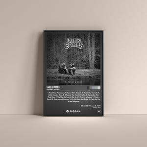 May include: Black and white album cover art for Luke Combs' album "Fathers & Sons". The album cover features a black and white photo of three men standing in a forest. The album title is printed in white text on a black background. The album tracklist is printed below the album title.