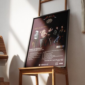 Op de afbeelding: Een zwart ingelijste poster met een rode achtergrond waarop een band genaamd Panic! At The Disco te zien is. De poster heeft een foto van de bandleden en de albumtitel "A Fever You Can't Sweat Out". Het album is uitgebracht op 27 september 2005.