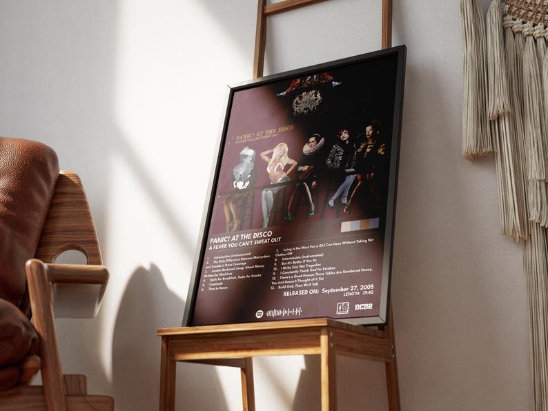 Op de afbeelding: Een zwart ingelijste poster met een rode achtergrond waarop een band genaamd Panic! At The Disco te zien is. De poster heeft een foto van de bandleden en de albumtitel "A Fever You Can't Sweat Out". Het album is uitgebracht op 27 september 2005.
