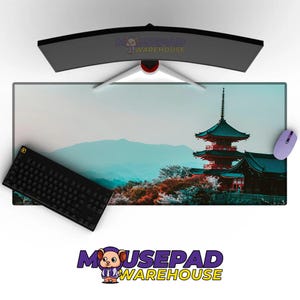 May include: A large rectangular mousepad featuring a Japanese pagoda scene with a black keyboard and a purple mouse. The mousepad has a scenic background with mountains and trees. The monitor is curved.