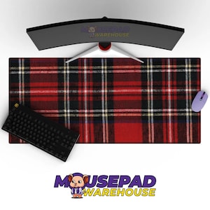 Puede incluir: Alfombrilla de ratón rectangular con un patrón de cuadros rojos, negros y blancos, con un teclado negro y un ratón morado. La alfombrilla cubre una gran superficie. También se ve un monitor curvo.