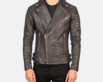 Könnte beinhalten: Eine schwarze Lederjacke im Biker-Stil mit Used-Look. Die Jacke hat einen Reißverschluss, einen Stehkragen und gesteppte Details an den Ärmeln.