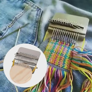 Puede incluir: Una herramienta de tejido de metal con una serie de ganchos y una base de madera se muestra parcialmente insertada en una prenda de mezclilla. La tela tejida es multicolor con hebras de hilo de varios colores.