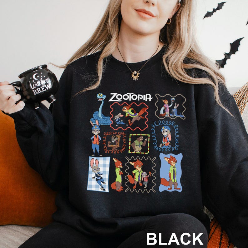 Puede incluir: Sudadera negra de cuello redondo con un gr&aacute;fico colorido de personajes de la pel&iacute;cula animada "Zootopia". El dise&ntilde;o incluye el t&iacute;tulo de la pel&iacute;cula y varias ilustraciones de personajes dentro de marcos decorativos. La palabra "BLACK" est&aacute; impresa en la parte inferior.